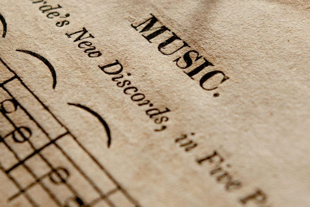 Detailed view of antique music sheets featuring notes and Monteverde's New Discords in sepia tone.